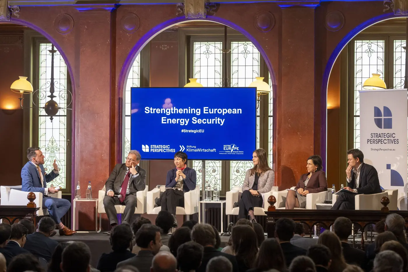 Moderator hosting a panel at a European policy conference